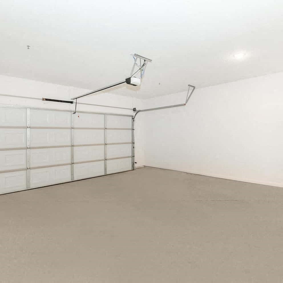 an empty garage with a white wall and a garage door