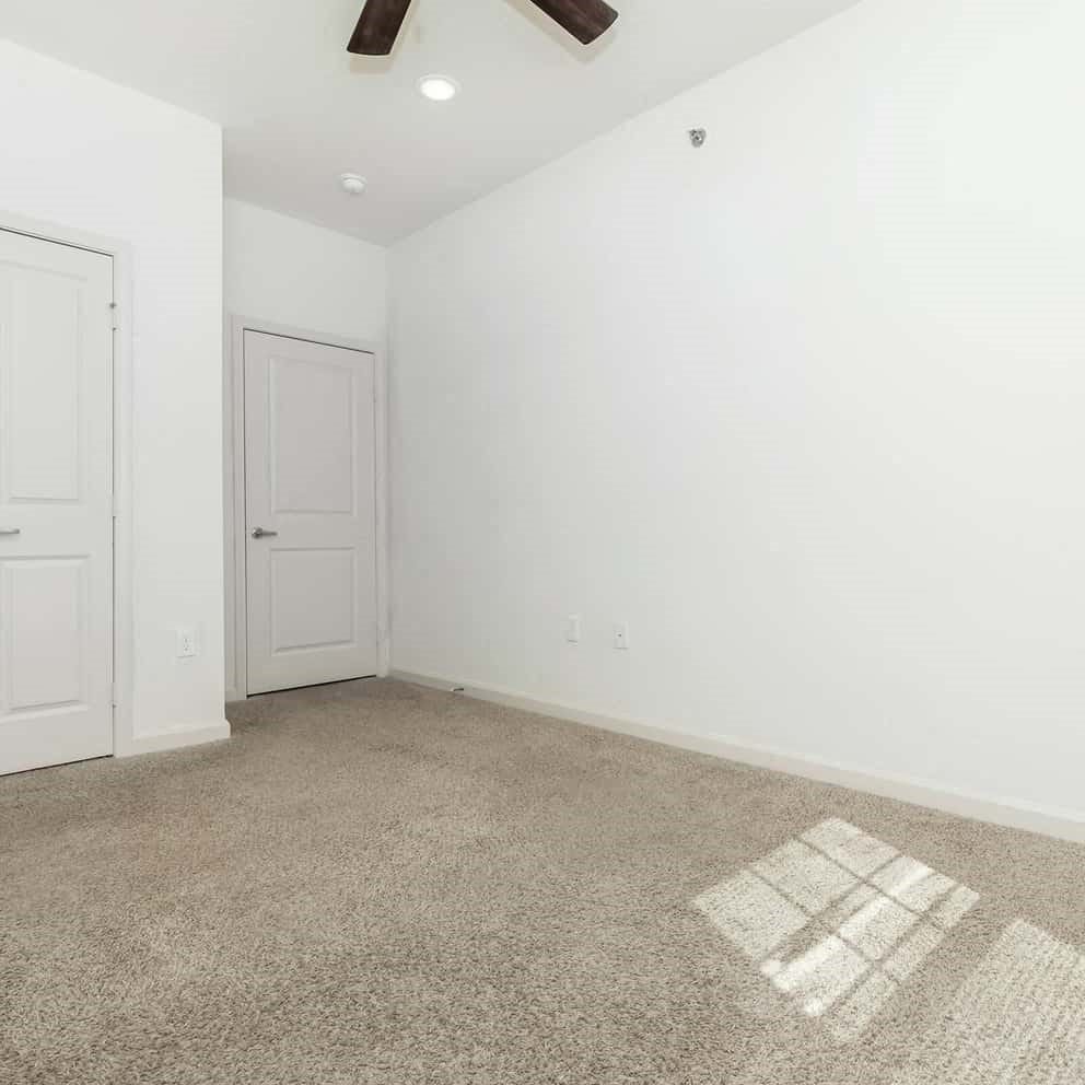 an empty room with white walls and carpet and a door