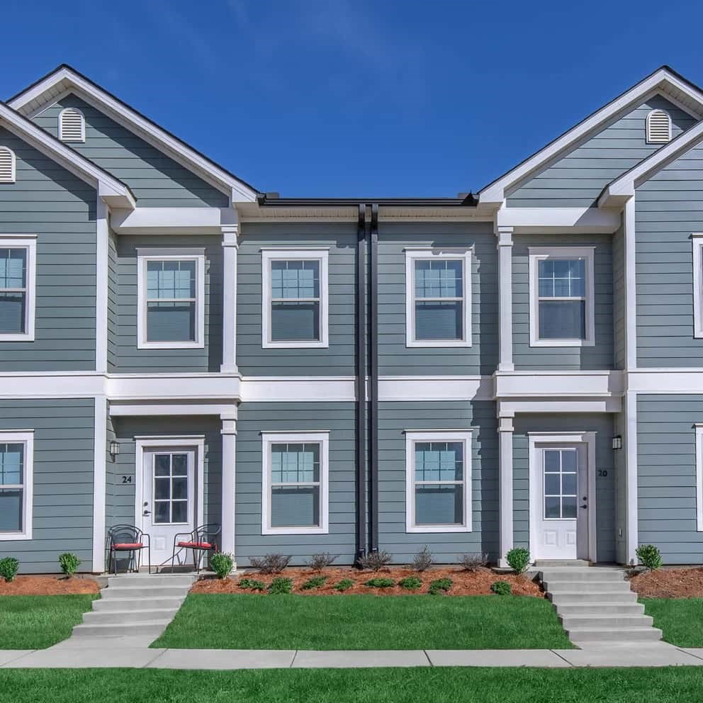 an apartment building with a lawn in front of it