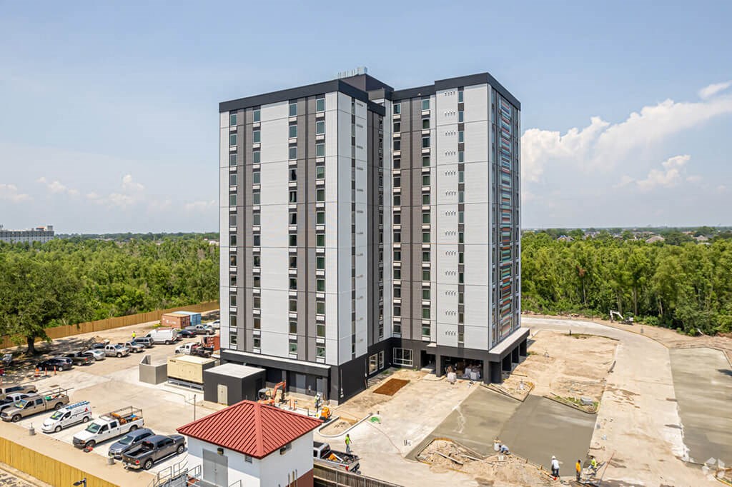 a high rise apartment building in front of a parking lot