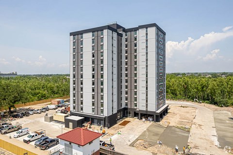 a high rise apartment building in front of a parking lot