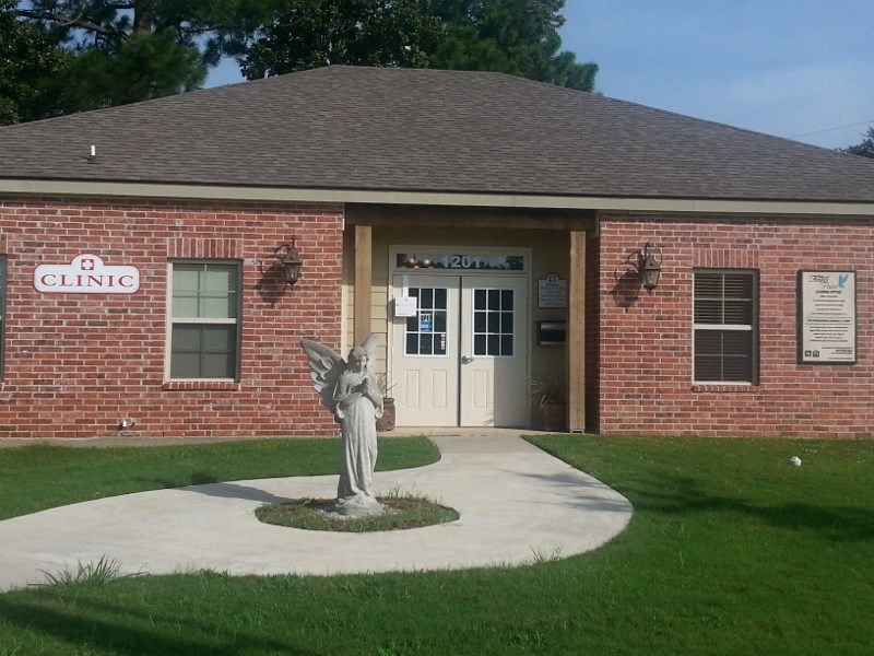 a statue of an angel in front of a brick building