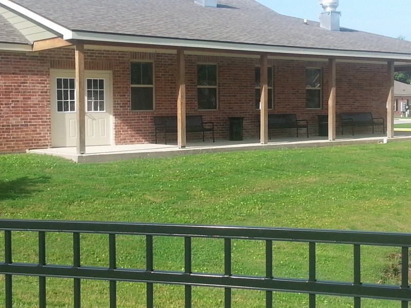 a patio with a fence in front of a brick building