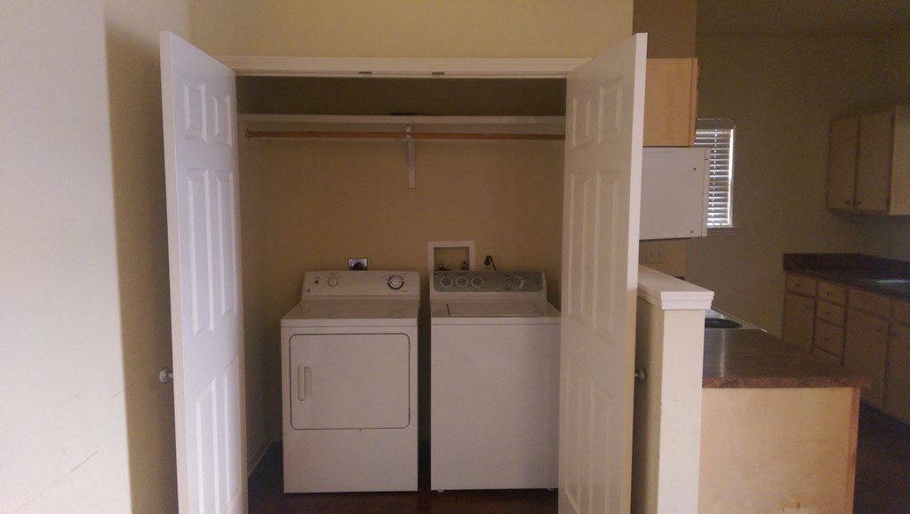 an empty laundry room with a washer and dryer in it
