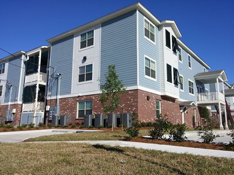 A blue and white apartment building with a brick base.