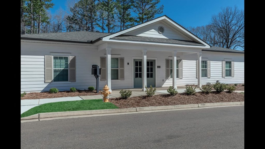 a white house with a yellow fire hydrant in front