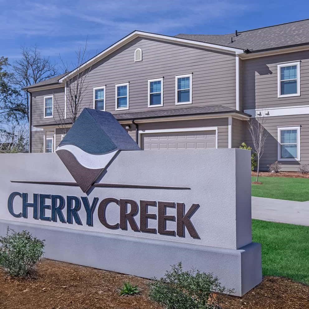 a sign for cherry creek in front of a house