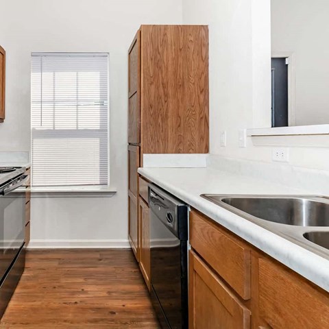 a kitchen with wooden cabinets and a sink and a window