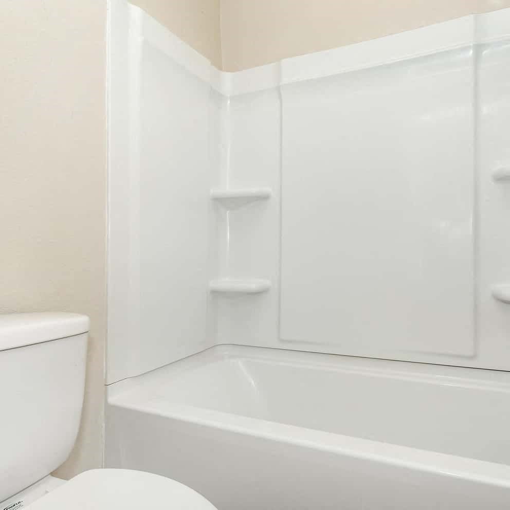 a white bathroom with a toilet and a tub