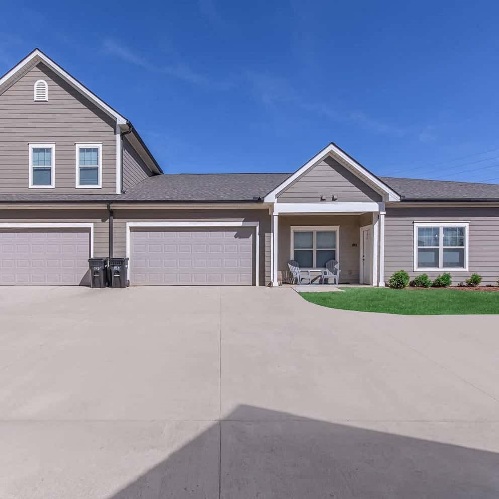 an empty driveway in front of a house