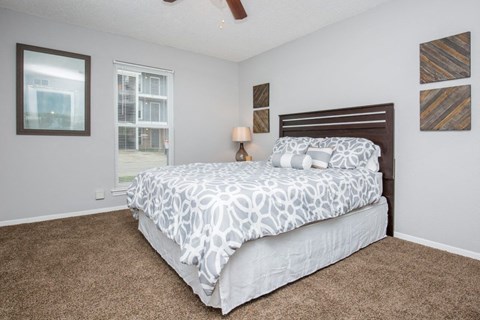 A bedroom with a large bed and a ceiling fan.