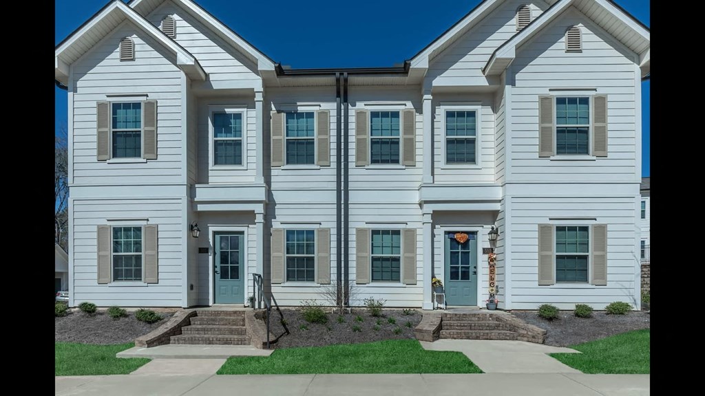 a white house with blue doors and a lawn