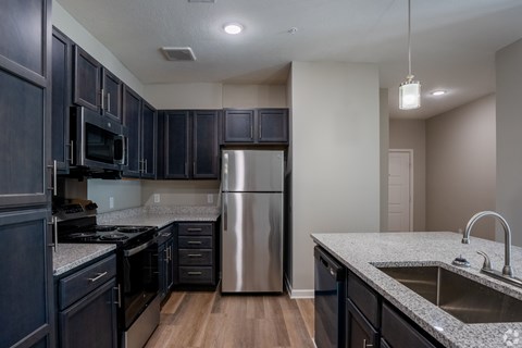 A kitchen with dark wood cabinets and stainless steel appliances.