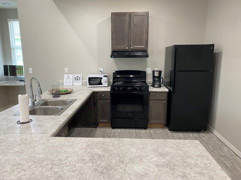 a kitchen with black appliances and a sink and a refrigerator