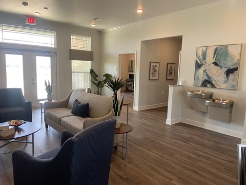 A living room with a couch, chair, and a painting on the wall.