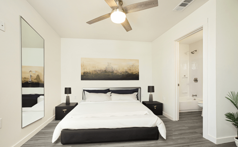 A bedroom with a large bed and a painting on the wall.