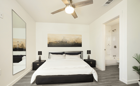 A bedroom with a large bed and a painting on the wall.