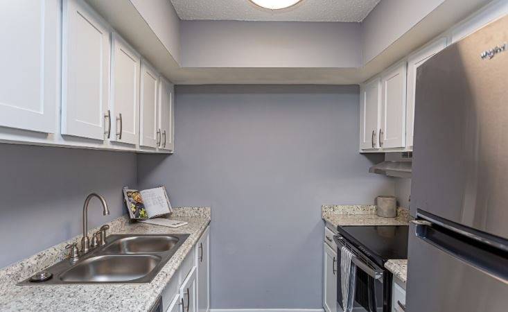 A kitchen with a sink and a refrigerator.