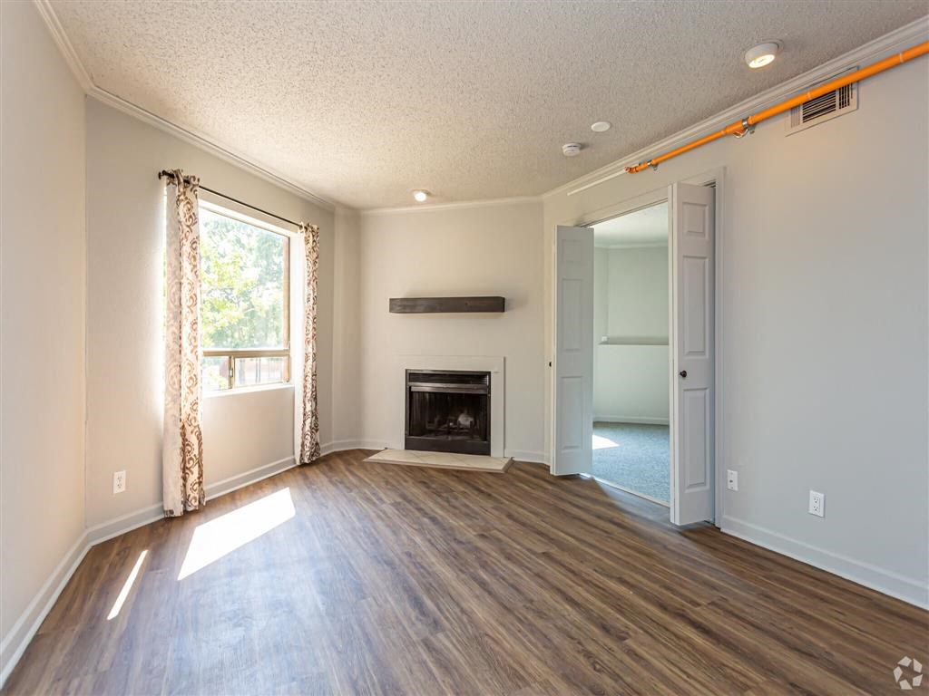a living room with a fireplace and wooden floors