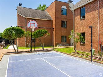 a basketball court in front of a brick building