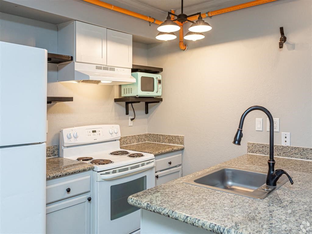 a kitchen with white appliances and granite counter tops