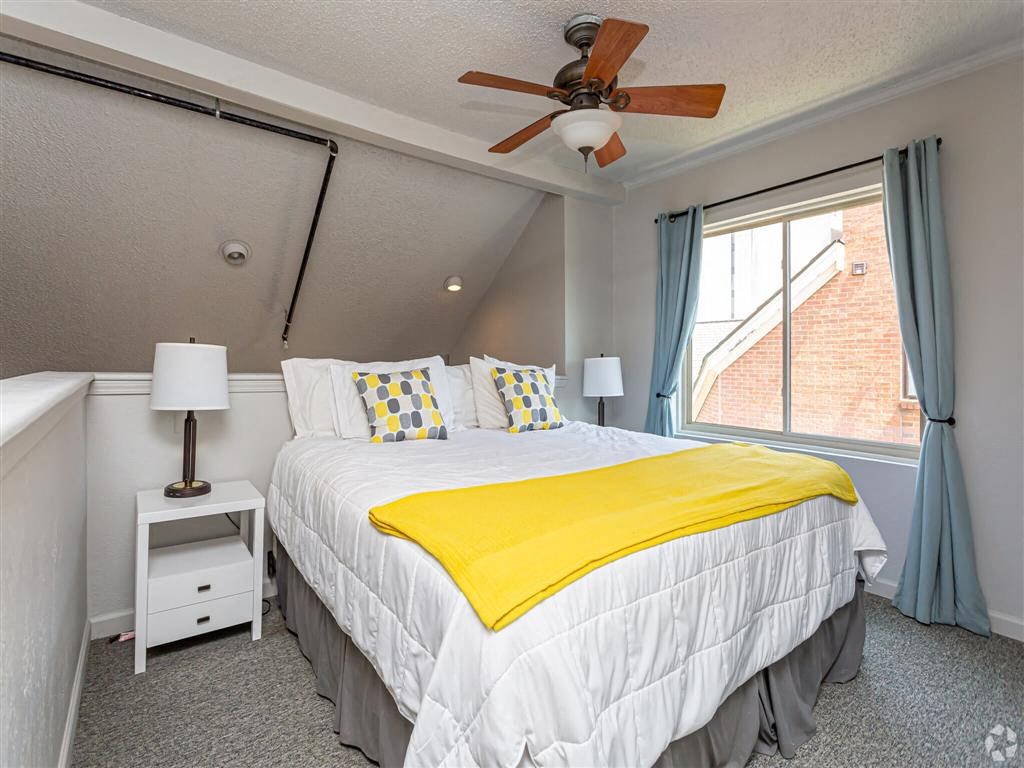 a bedroom with a bed and a ceiling fan
