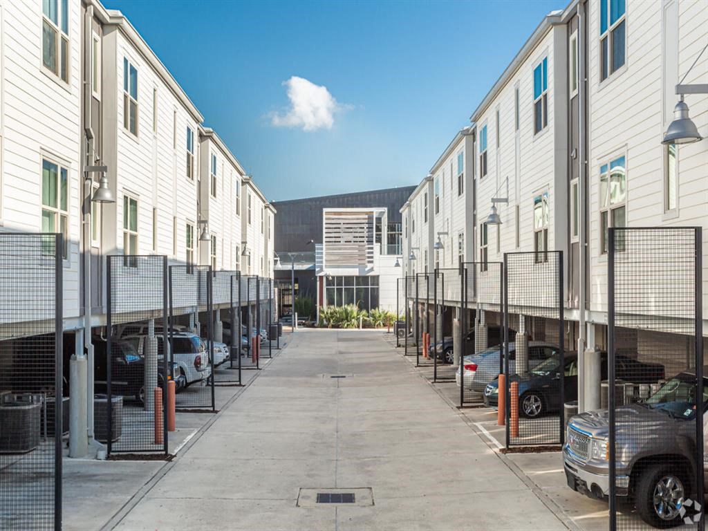 a row of rental apartments with cars parked in front of them