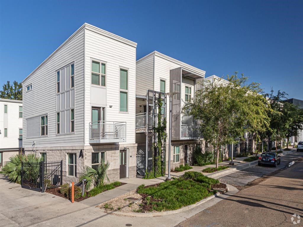 a row of white houses with balconies on a city street