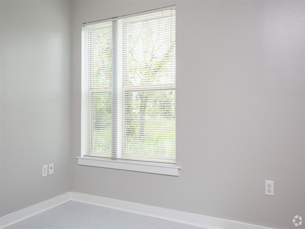 a window in a white room with blinds on it