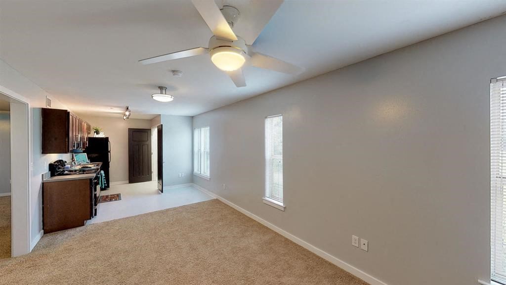 an empty living room with a ceiling fan
