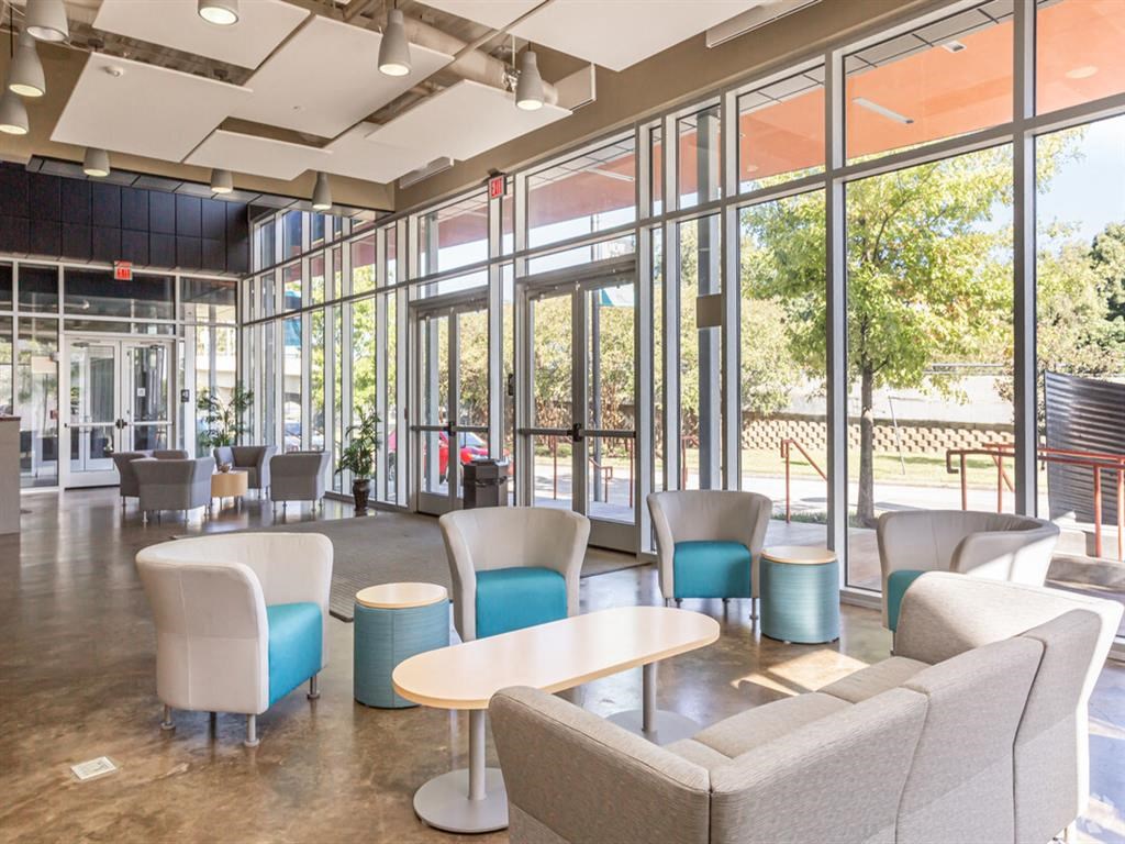 a lobby with couches chairs and tables and windows