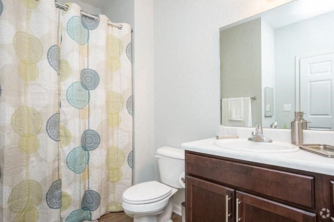 a bathroom with a shower curtain and a toilet and a sink