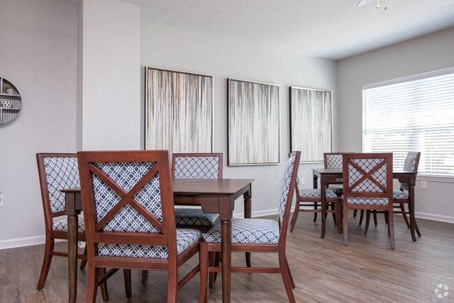 a dining room with a wooden table and chairs