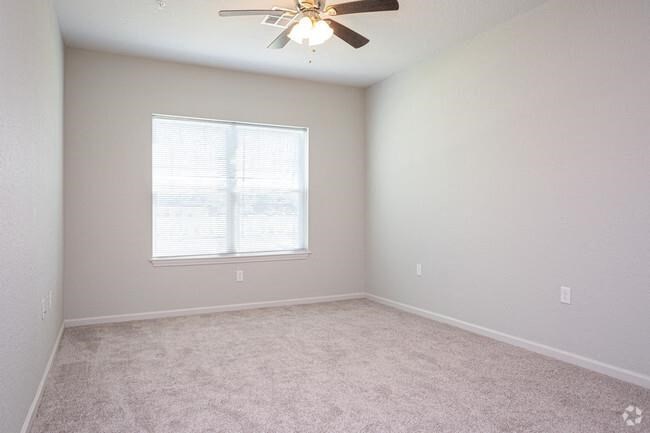 an empty room with a ceiling fan and a window