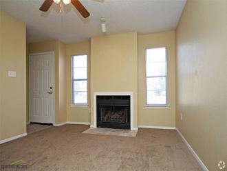 a living room with a fireplace and a ceiling fan - Photo Gallery