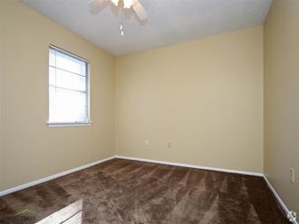 an empty room with a ceiling fan and a window - Photo Gallery