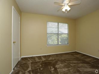an empty room with a ceiling fan and a window - Photo Gallery