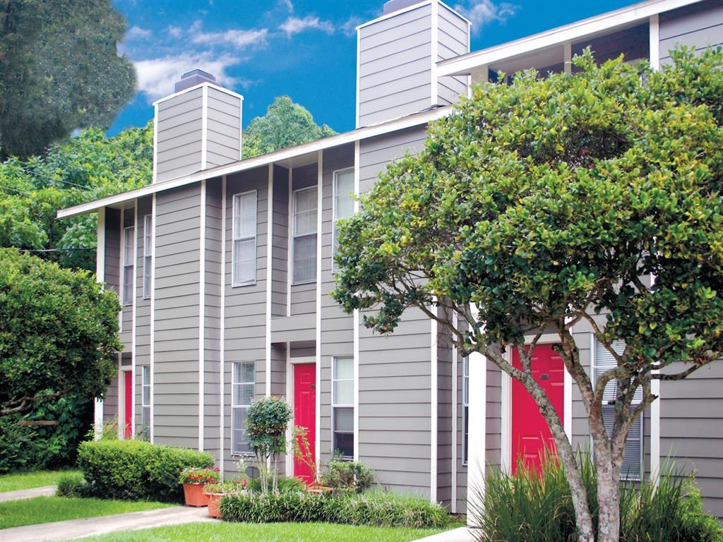 a gray apartment building with red doors