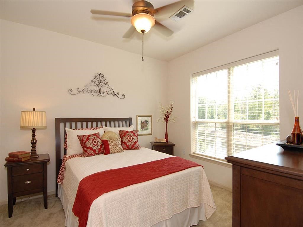a bedroom with a bed and a ceiling fan