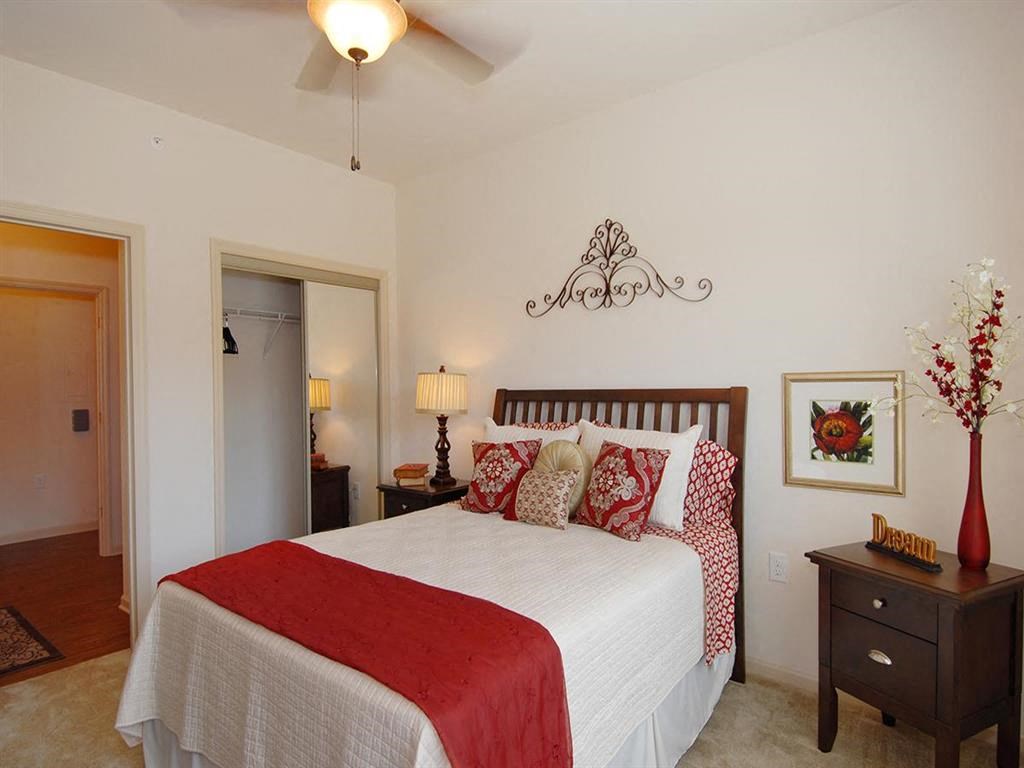 a bedroom with a bed and a ceiling fan