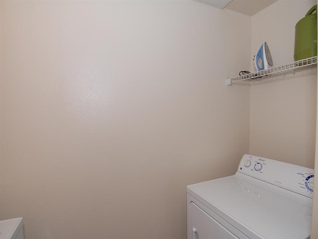 a white bathroom with a washer and dryer in it
