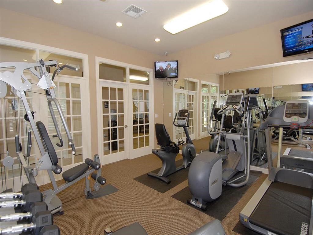 a gym with various exercise equipment and a television