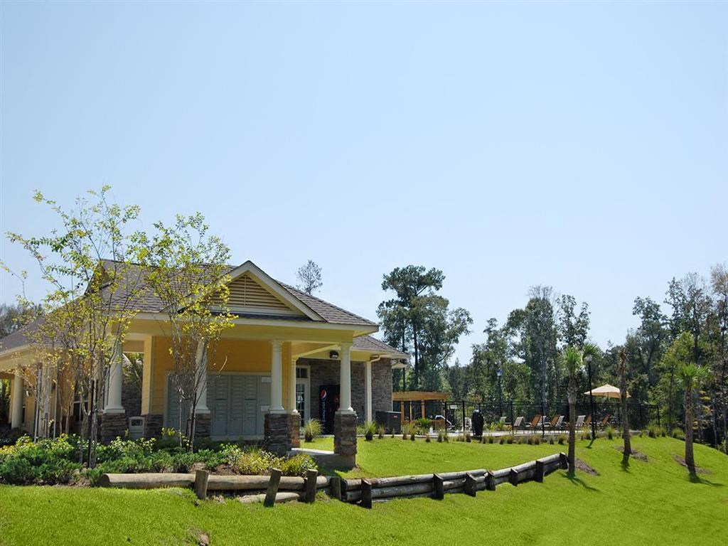 a house with a lawn and trees in front of it
