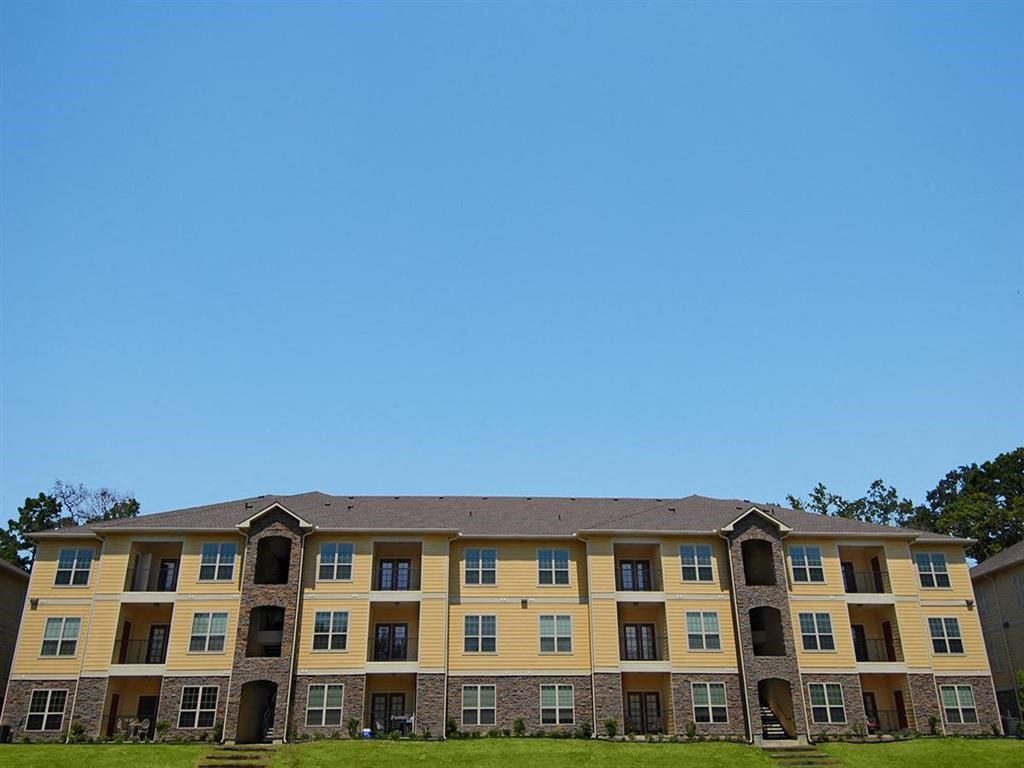 a large apartment building with a blue sky in the background