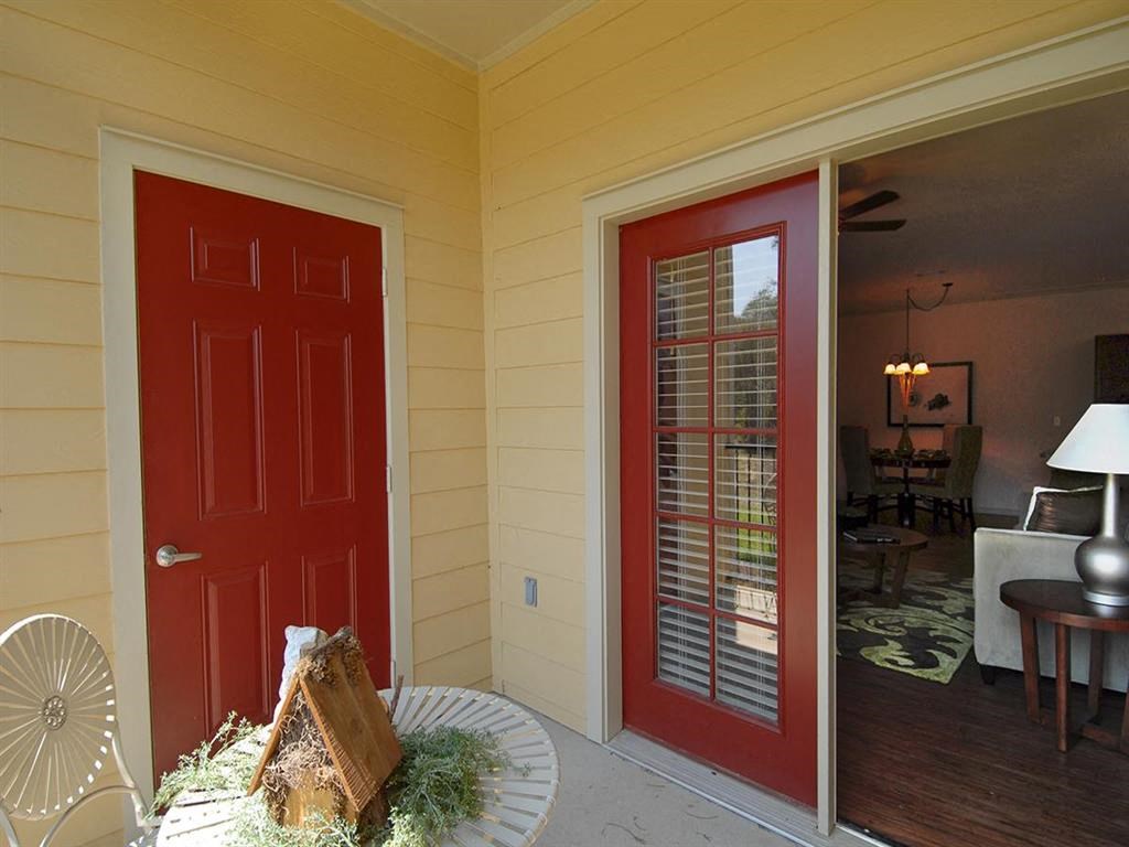a porch with a red door and a table with a cake on it
