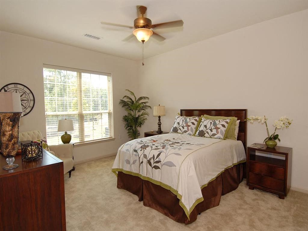 a bedroom with a bed and a ceiling fan