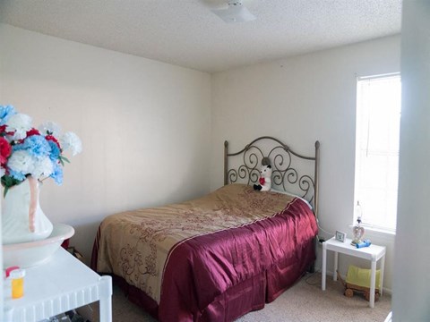a bedroom with a bed and a vase of flowers