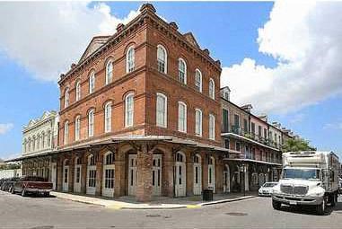 A red brick building with white trim and a truck parked in front.