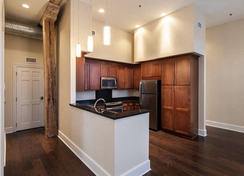 A kitchen with wooden cabinets and a white island.