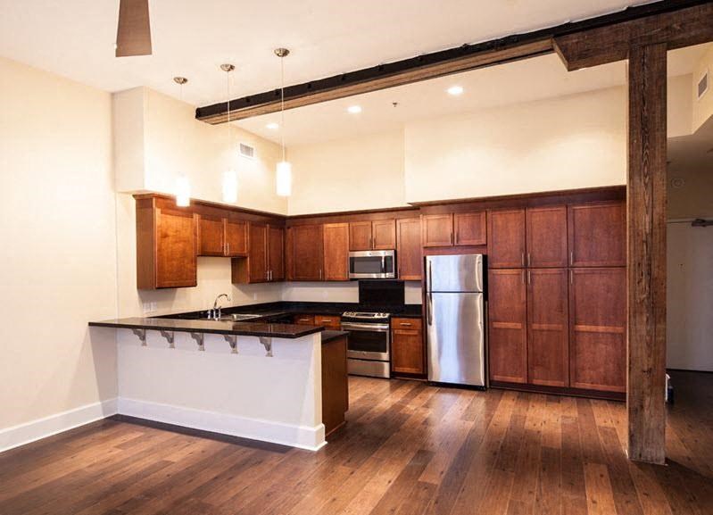 A kitchen with wooden cabinets and a white island.